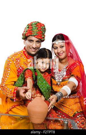 3 indian Rajasthani Villager Parents and daughter Piggy Bank Saving money Stock Photo