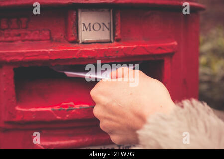 Closeup on a woman's hand as she is posting a letter Stock Photo