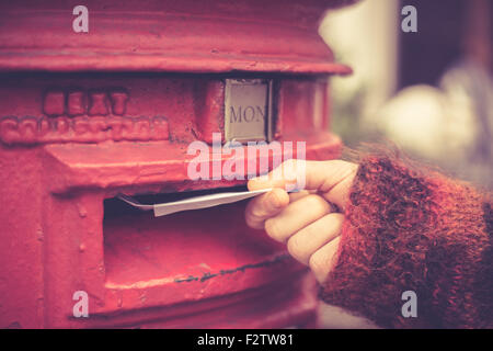Closeup on a woman's hand as she is posting a letter Stock Photo