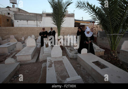 Sept. 24, 2015 - Nablus, West Bank, Palestinian Territory - Palestinian women pray over the graves of relatives in a cemetery, on the Muslim holiday of Eid al-Adha or or the feast of sacrifice, in the West Bank City of Nablus on September 24, 2015. Muslims across the world are celebrating the annual festival of Eid al-Adha, or the Festival of Sacrifice, which marks the end of the Hajj pilgrimage to Mecca and in commemoration of Prophet Abraham's readiness to sacrifice his son to show obedience to God  (Credit Image: © Nedal Eshtayah/APA Images via ZUMA Wire) Stock Photo