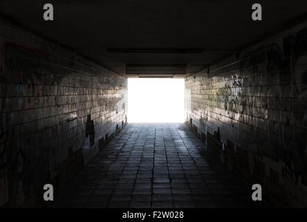Underground passage. Old weathered dirty walls with graffiti. Stock Photo