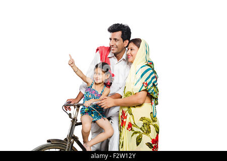 3 indian Rural farmer Parents and daughter  Riding Bicycle finger pointing Stock Photo