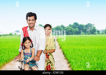 3 indian Rural farmer Parents and daughter farm Riding Bicycle Stock Photo