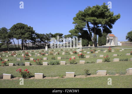 Plots of tombstones and red roses planted in between. CWGC portianou cemetary. Limnos island, Greece Stock Photo