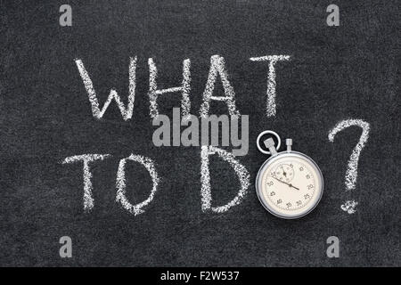 what to do question handwritten on chalkboard with vintage precise stopwatch used instead of O Stock Photo