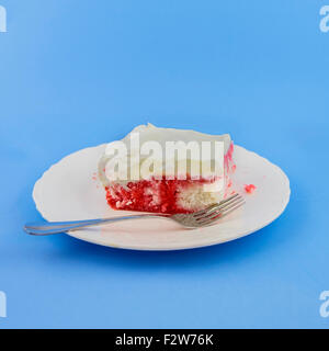 A piece of homemade soda-pop cake on a white dessert plate on a blue background. USA. Stock Photo