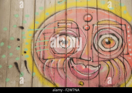 Detail of street art. Colourful graffiti of a sunny smiling face painted on a window shutter by the artist known as Loko. Montpellier, South of France. Stock Photo