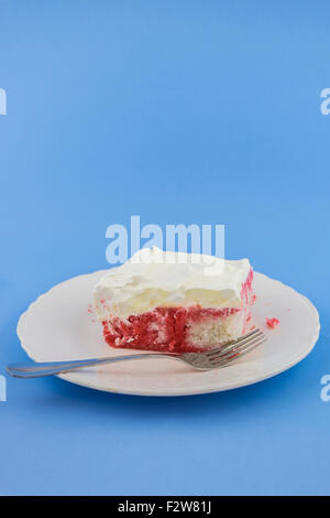 A piece of homemade soda-pop cake on a white dessert plate on a blue background. USA Stock Photo