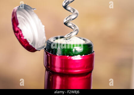 Steel corkscrew opening a bottle of red wine Stock Photo