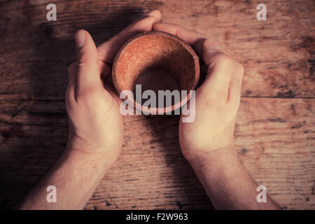 Two hands are holding a leather dice cup at a table Stock Photo