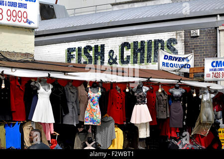 London, England, UK.  Camden Market - clothes stall / fish and chip shop behind Stock Photo