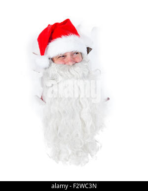 Santa Claus looking through hole in a white wall Stock Photo