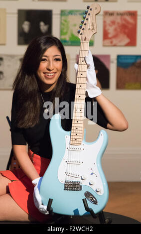 London, UK. September 24th, 2015. A Sotheby's worker poses with Eric Clapton's Fender Stratocaster, featured in an exhibition running 24th - 28th September ahead of an auction on September 29th. The exhibition gathers together lyrics, instruments, stage costumes and artworks from some of the world's greatest pop and rock performers and groups, including Abba, The Beatles, Bob Dylan, Pink Floyd and Bruce Springsteen. Credit:  Paul Davey/Alamy Live News Stock Photo