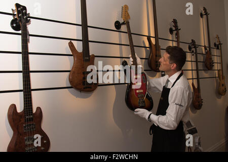 London, UK. September 24th, 2015. A Sotheby's Gallery Technician arranges a display of basses owned by Cream's Jack Bruce.  They feature in the auctioneers Rock and Pop exhibition running 24th - 28th September ahead of an auction on September 29th. The exhibition gathers together lyrics, instruments, stage costumes and artworks from some of the world's greatest pop and rock performers and groups, including Abba, The Beatles, Bob Dylan, Pink Floyd and Bruce Springsteen. Credit:  Paul Davey/Alamy Live News Stock Photo