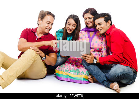 4 indian family Parents young daughter and son laptop Chatting Stock Photo