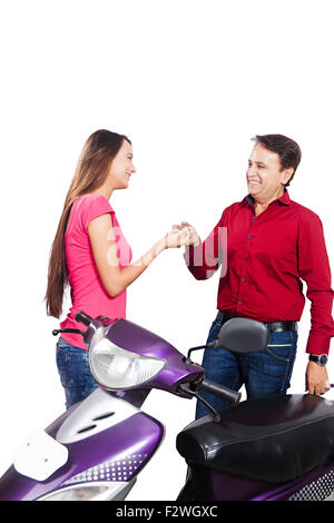 2 indian father and young daughter Giving key Gift Scooty Stock Photo