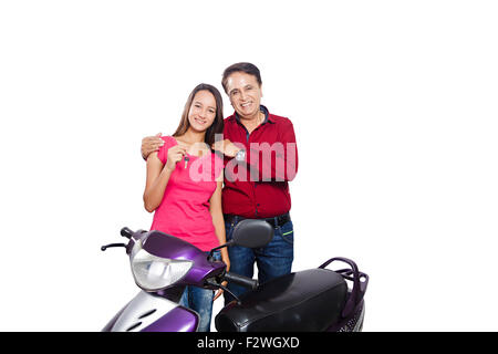 2 indian father and young daughter showing key Gift Scooty Stock Photo