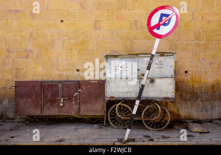 A damaged, bent 'No Parking' signboard on roadside footpath in India. Stock Photo