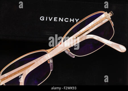 Givenchy designer glasses with coated lenses for computer use giving blue tinge resting on black case Stock Photo