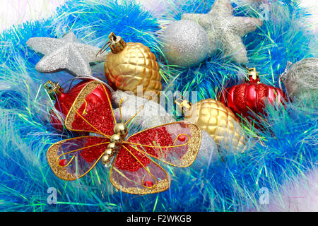 Christmas ornaments, silver stars, golden pine cones, balls and red lanterns, colored tinsel. Stock Photo