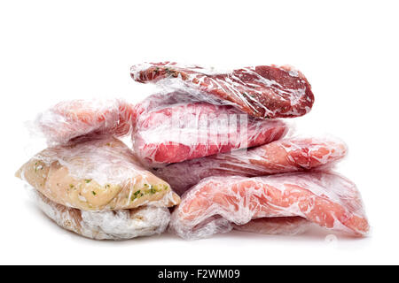frozen raw meat, such as pork, chicken or beef, wrapped in plastic on a white background Stock Photo