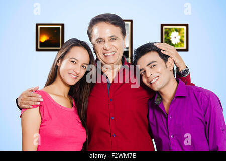 3 indian father and young son and daughter standing Stock Photo