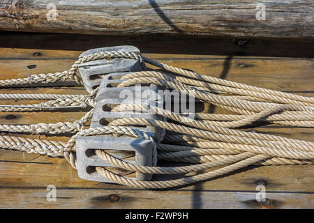 Ropes in wooden pulleys / blocks on deck of sailing boat / yacht Stock Photo