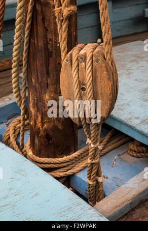 Rope in wooden pulley / block on deck of sailing boat / fishing boat Stock Photo