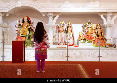 Hindu woman and statues of Hindu Gods in Reading Hindu Temple, Reading, Berkshire England UK, example of multicultural Britain Stock Photo