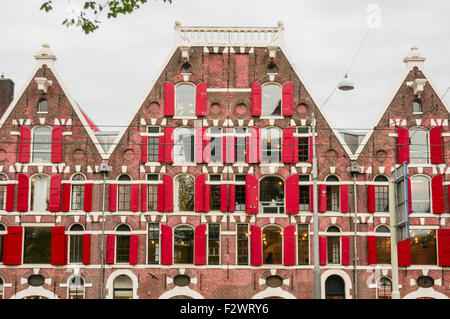 Building in Amsterdam with lots of red window shutters. Stock Photo