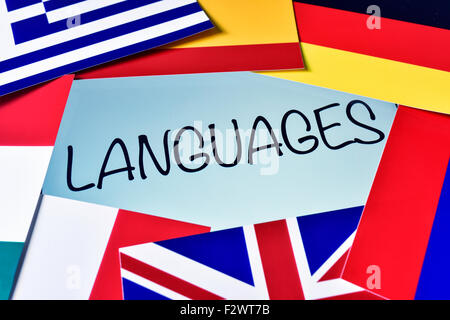 the word languages in the screen of a tablet computer surrounded by flags of different countries Stock Photo