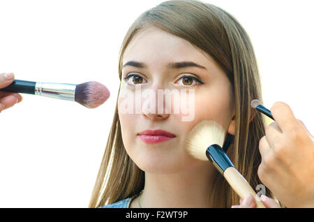 Young woman teenager having make up on her face by others in studio Stock Photo