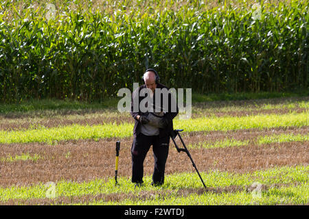 Lathom, Lancashire, UK. 24th September, 2015.  Metal detectorists scanning a recently harvested field in search of hidden treasures.  Many farmers welcome the treasure hunters as long as it is after harvest time. Ploughed fields generally offer the greatest prospects for making good finds and are the most favoured sites for any detectorist. This is mainly because they are continuously being turned over, bringing new finds to the surface.  (Images taken from public footpath). Credit:  Cernan Elias/Alamy Live News Stock Photo
