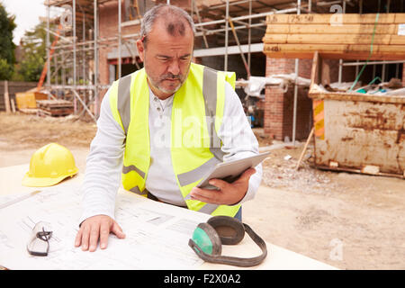 Construction Worker Using Digital Tablet On Building Site Stock Photo