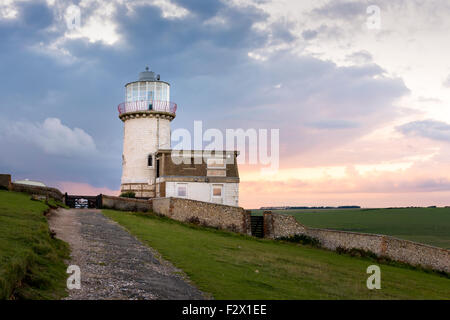 Glowing against the evening sky, the Belle Tout (Belle Toute) lighthouse atop the Seven Sisters Cliffs near Beach Head on th Stock Photo