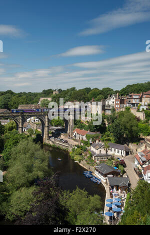 Blue sky above Knaresborough, England, UK - scenic sunny summer view of train on viaduct bridge, River Nidd, boats, wooded gorge & riverside houses. Stock Photo