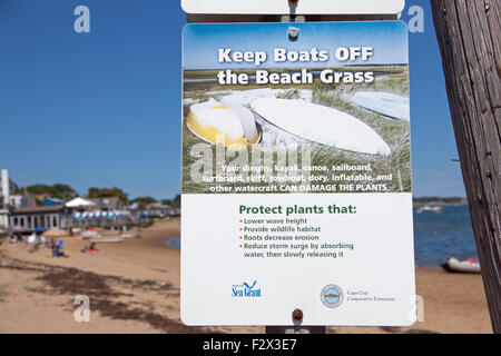 Sign saying to keep boats off of beach grass in order to protect beneficial beach grass. Stock Photo