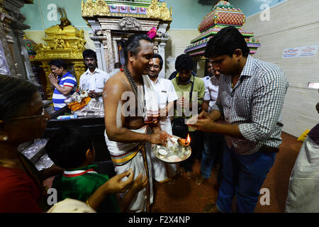 A Hindu priest performing a puja ceremony inside the Sri Veeramakaliamman Temple in Little India, Singapore. Stock Photo