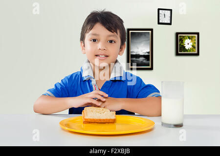1 indian kid boy Breakfast eating Bread Stock Photo