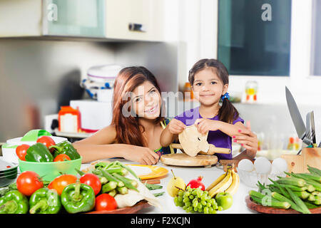 2 indian Mother and kid daughter Kitchen Cooking Stock Photo