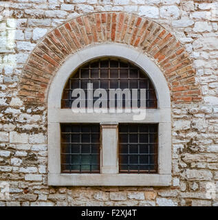 old window with metal bars in a brick wall Stock Photo
