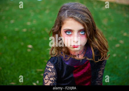 Halloween makeup kid girl blue eyes in outdoor backyard lawn Stock Photo