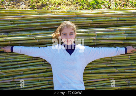 Kid girl relaxed in green canes background in autumn winter Stock Photo