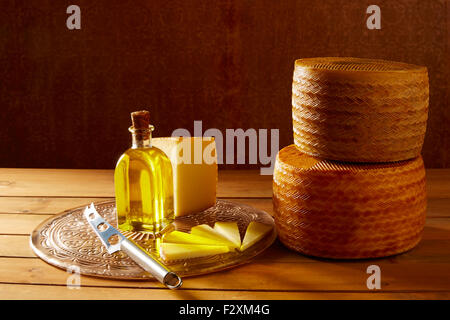Manchego cheese from Spain in wooden table with andalusian olive oil