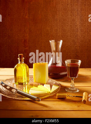 Manchego cheese from Spain with olive oil and red wine on wood Stock Photo
