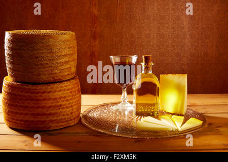Manchego cheese from Spain with olive oil and red wine on wood Stock Photo