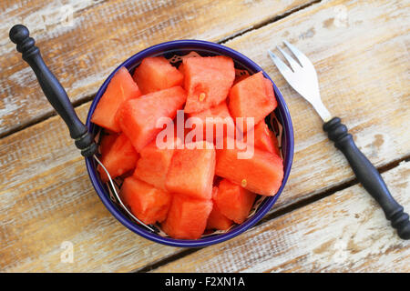 Watermelon cubes in bowl on rustic wooden surface Stock Photo