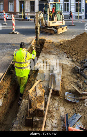 construction workers digging excavating trench machine Stock Photo