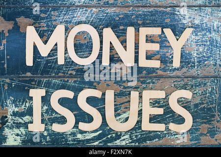 Money issues written on rustic wooden surface Stock Photo
