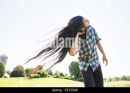 A young man shaking his head with hisl ong hair flowing in the breeze. Stock Photo